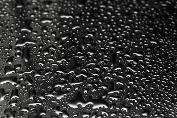 Shiny water drops on a dark glass. Water drops on black surface.
