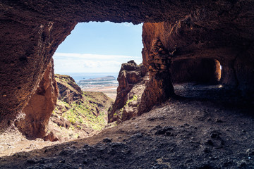 Cuatro Puertas, aka four doors caves or Cueva de los Papeles, archaeological site in Gran Canaria, Spain. View from the inside of the cave..
