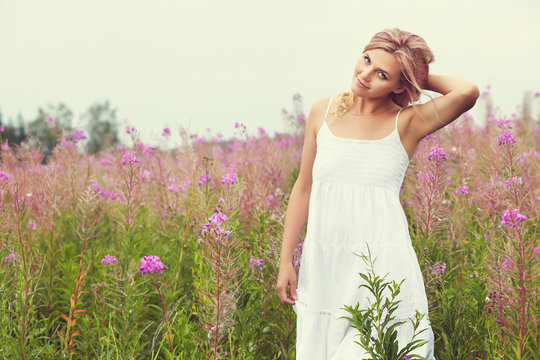 outdoor portrait of a middle aged blonde woman. attractive sexy girl in a field with flowers