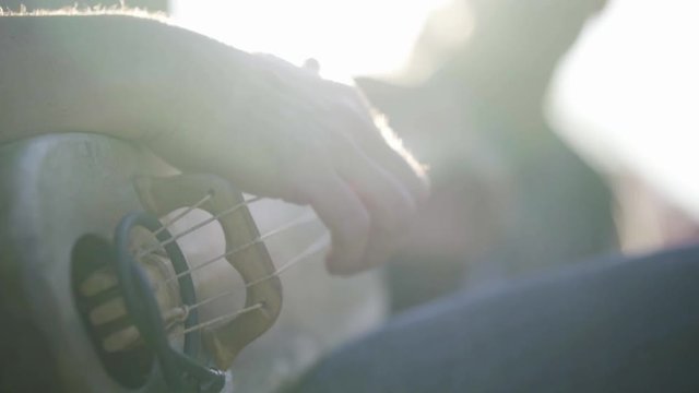 Gros plan sur une guitare traditionnel &agrave; 5 cordes. Slowmtion et flares naturel.