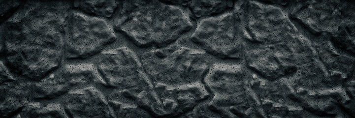 Black aged stone wall wide texture. Dark rough surface large background