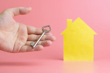 Rental housing concept. Hand with key - symbol of buying or selling real estate in mortgage loan.