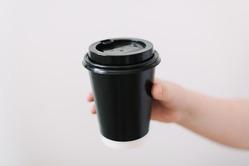 black paper cup of coffee take away. Disposable cup on a white background. Place for text.