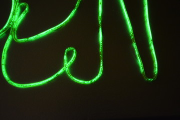Toxic green lime lighting with a specific pattern. Woven filaments, cable, wires with outgoing light. Neon electroluminescent wire in the form of night lighting.