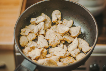 The process of cooking chicken breast diet for an athlete in a frying pan in sunflower oil. Meat for muscle recovery after exercise.