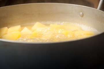 Cooking a traditional dish of boiled potatoes. Boil potatoes in an aluminum pan.
