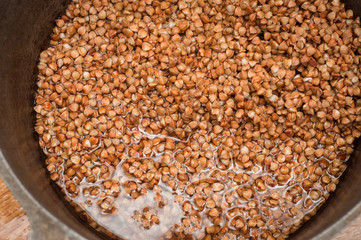 Washing of buckwheat in water in a cast iron cauldron