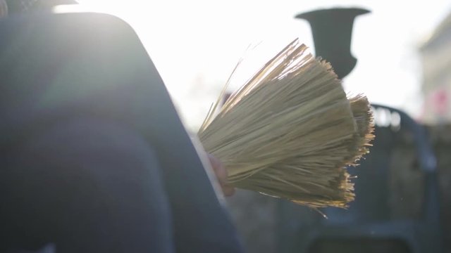Musicien qui joue du balais en ext&eacute;rieur. Slowmotion avec flares.