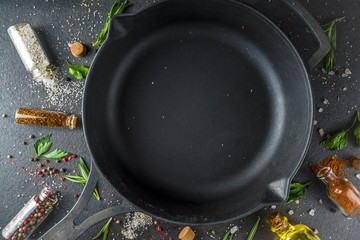 Cooking food background with herbs, olive oil and spices, black stone concrete background above copy space