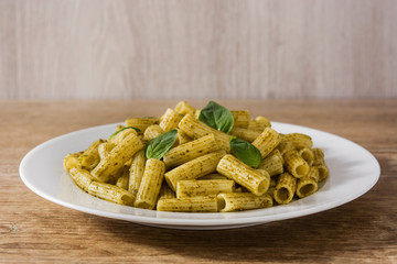 Penne pasta with pesto sauce on wooden table