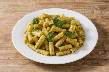 Penne pasta with pesto sauce on wooden table