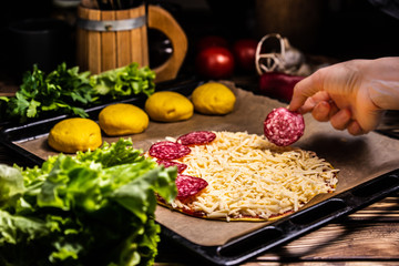 Raw pizza with cheese and salami