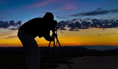 Fotograf mit Stativ bei Sonnenuntergang