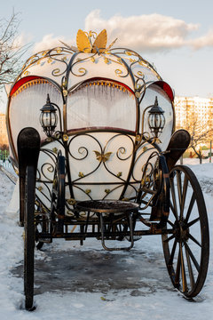 The white carriage with wrought iron elements is in the snow