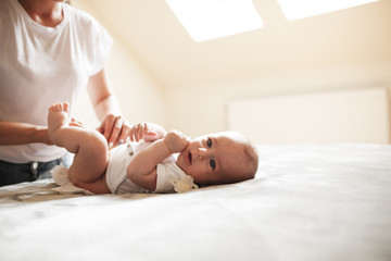 Mother changing her baby diapers.