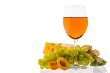 Amber wine. Wine in a glass near fruits, grapes and cheese. Traditional Georgian wine according to ancient technology. Isolated on white background. Copy space. Close up and horizontal orientation.