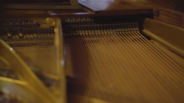 Gros plan dans un piano pendant qu'un homme joue.