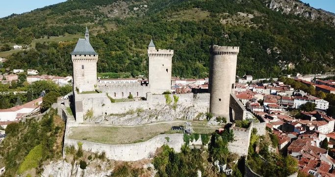 Aerial view of impressive medieval castle on rocky outcrop in French commune of Foix