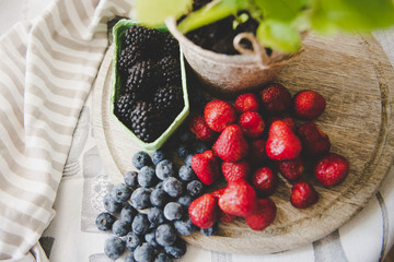 fresh strawberry blueberry and blackberry on wooden desk