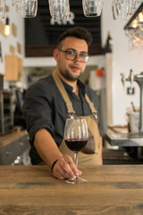 Waiter offering cup of wine in a pub