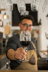 Waiter offering cup of wine in a pub
