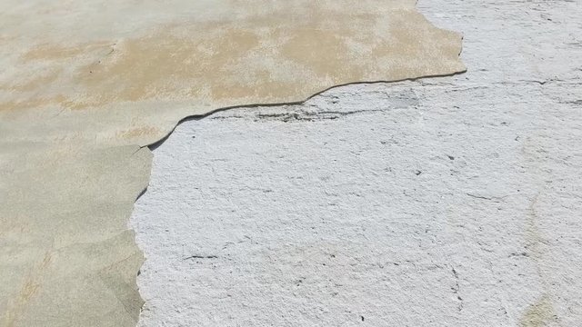 Bad foundations on old house cracked plaster facade wall with brick background under peeled cement, with motion 