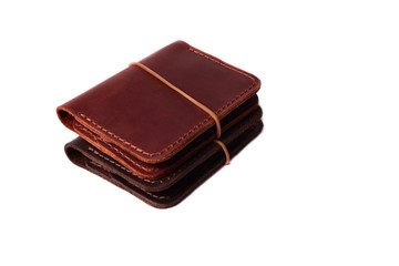 Handmade two red and brown leather cardholders with rubber band isolated on white background closeup. Stock photo of handmade luxury accessories.