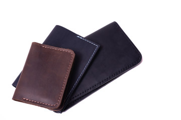 Handmade brown cardholder, black passport cover and purse isolated on white background closeup. Stock photo of handmade luxury accessories.