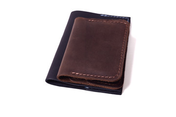 Handmade brown cardholder and black passport cover isolated on white background closeup. Stock photo of handmade luxury accessories.