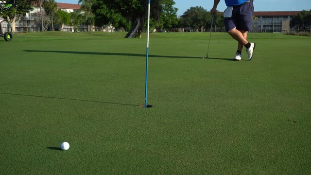 Dos golfistas se divierten jugando golf en el green.