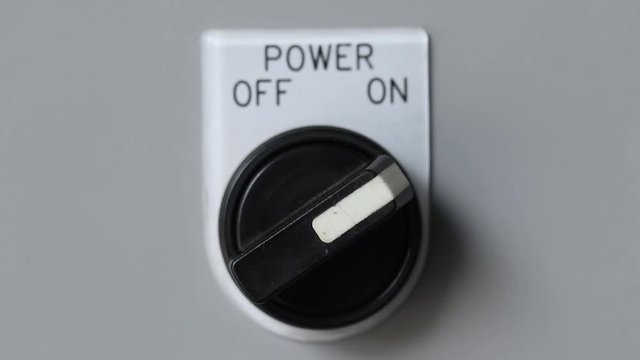 Close-up of hand turn on machine power switch 