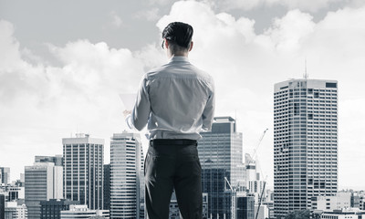 Concept of business success and control with confident boss against cityscape background