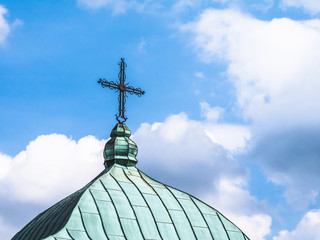 Fototapeta na wymiar Cross on the roof of the church tower detail