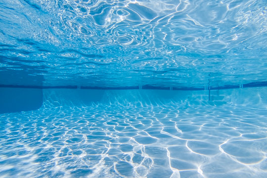 Underwater sunlight patterns in empty suburban swimming pool.  
