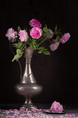 Vintage still life with pink roses and tin jug