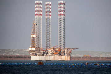 Oil rig moored in harbor with legs lifted