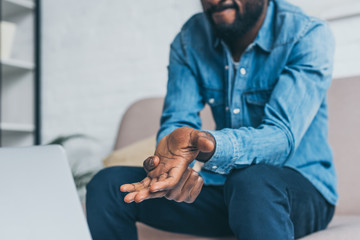 cropped view of african american man suffering from pain in hand