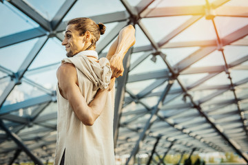 Close up of attractive athletic man practicing yoga and warming up outdoors.