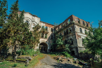 Ruined overgrown hospital in ghost mining town Akarmara, consequences of war in Abkhazia, green post-apocalyptic concept