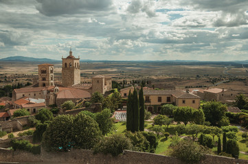 Fototapeta na wymiar Old buildings with church steeples and gardens in a rural landscape seen from the Castle of Trujillo.