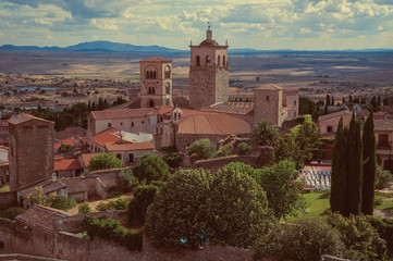 Obraz premium Old buildings with church steeples and gardens in a rural landscape seen from the Castle of Trujillo.