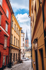 Narrow street of the old town. Gamla Stan, the oldest part of Stockholm, Sweden. Scandinavia, Northern Europe. Architectural landmark of Stockholm. Sunny weather with blue sky