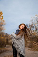 Young redhead woman with scarf in autumn park