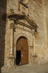 Wooden door with labored medieval stone decoration at Trujillo