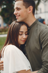 Fototapeta premium Cute couple in a city. Lady in a white dress. Boy in a green shirt