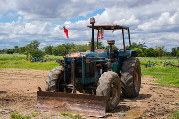 Tractors that are parked on the farm while not in use In the morning of the farm where the clouds were gathered before forming a rainstorm
