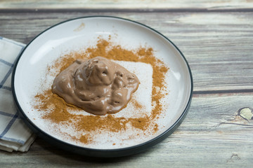Melting chocolate ice cream in white dish