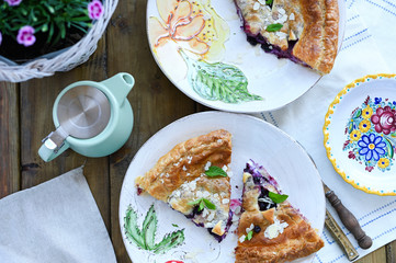 Homemade cake with puff pastry. Summer homemade pastries for a family breakfast. Photo in a rustic style of life. Portions for food on the table. Ceramic dishes beautiful. Copy space.