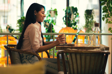 Confident young lady using laptop in the cafe
