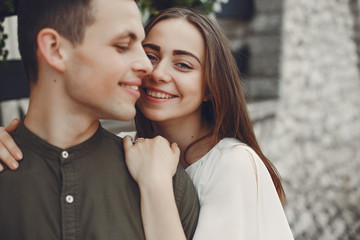 Cute couple in a city. Lady in a white dress. Boy in a green shirt